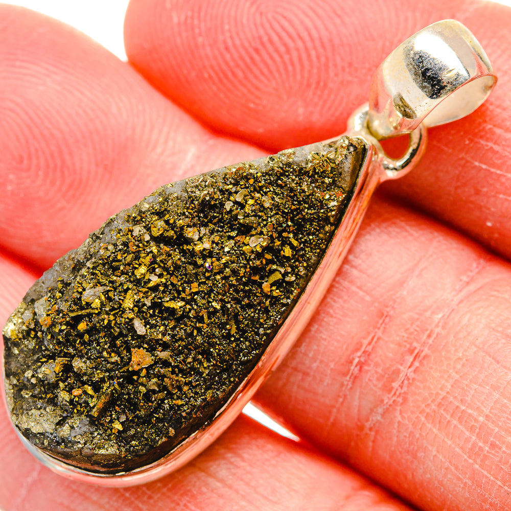 Close-up silver teardrop druzy pendant with gold-and-green speckled crystal stone