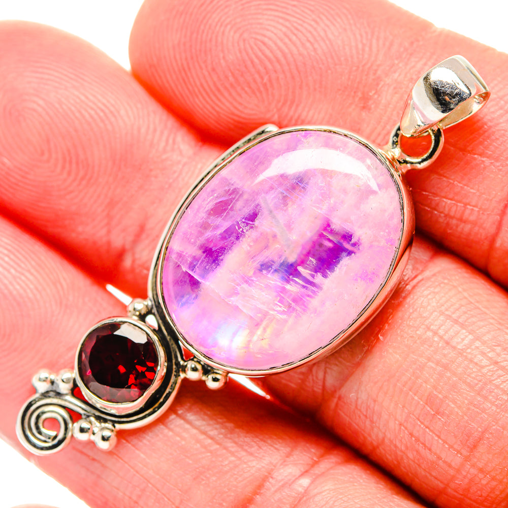 Close-up of 925 sterling silver oval pink moonstone pendant with red garnet accents
