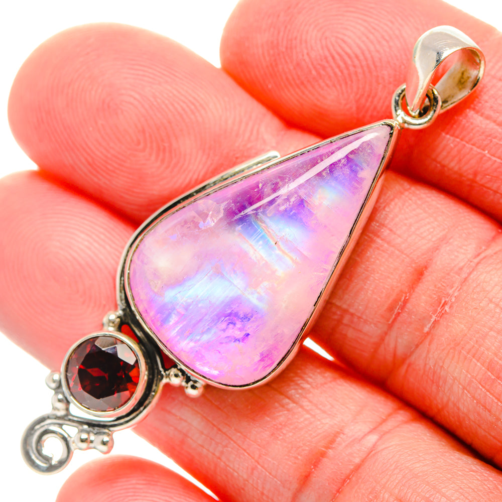 Close-up teardrop moonstone pendant with round red garnet stone in silver setting