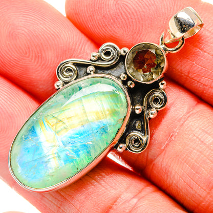 Sterling silver pendant with oval blue-green opal and round green gemstone in scroll frame