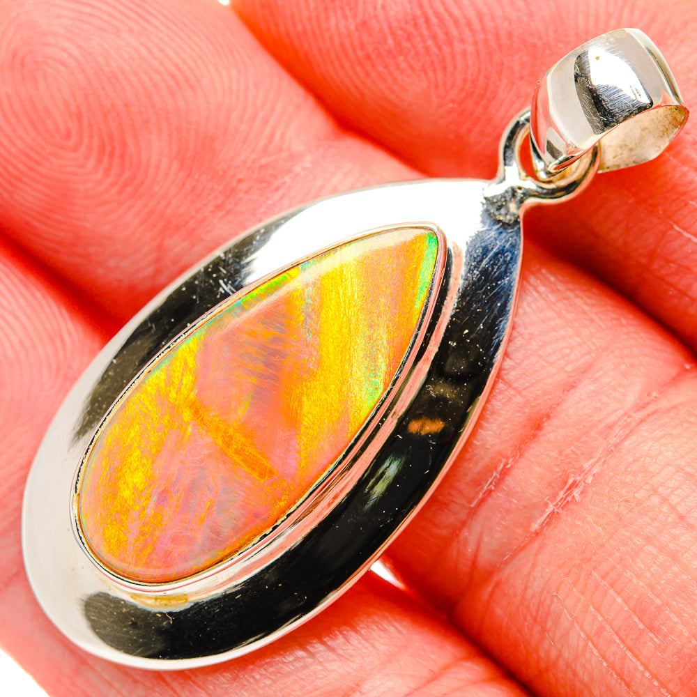 Opal pendant in oval bezel with iridescent opal and sterling silver frame