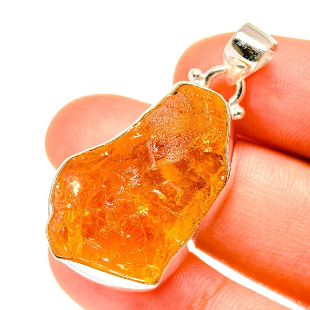 Rough citrine pendant on sterling silver bail, textured amber-orange stone.