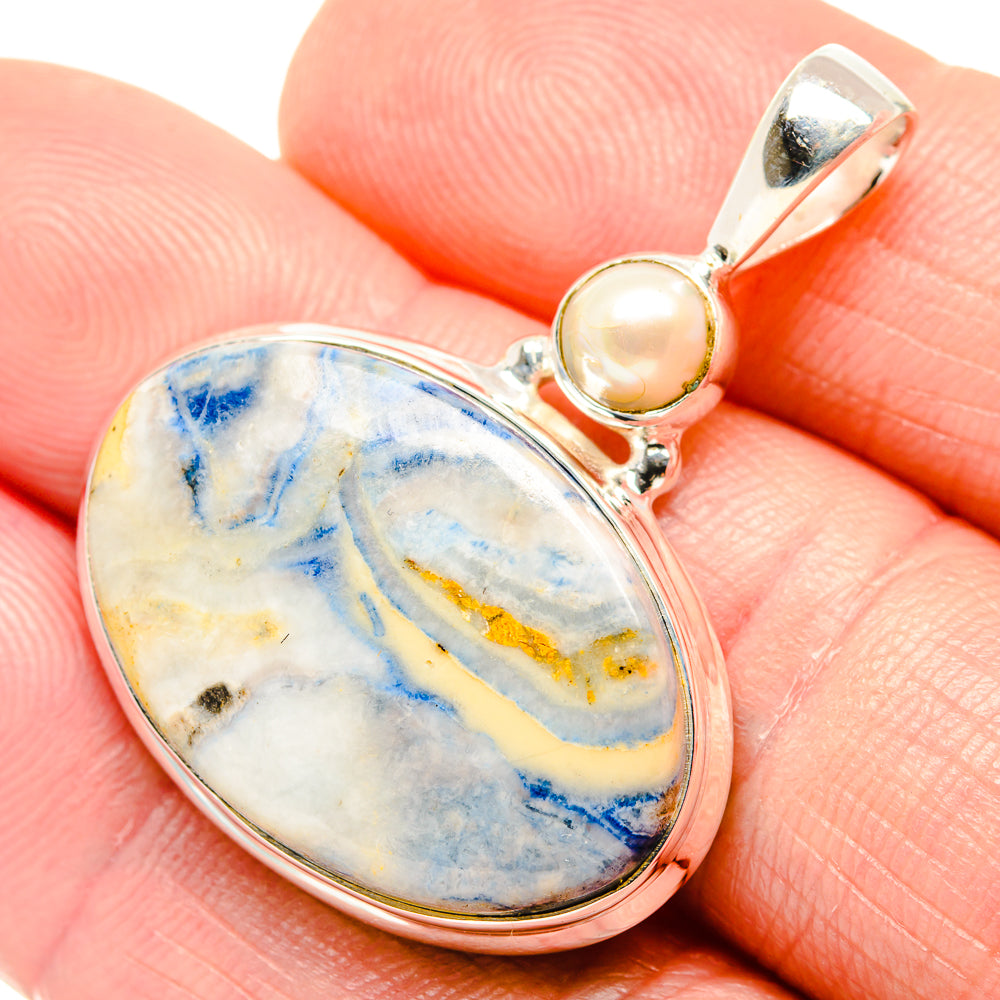 Close-up sterling silver pendant with oval blue scheelite and small round cultured pearl