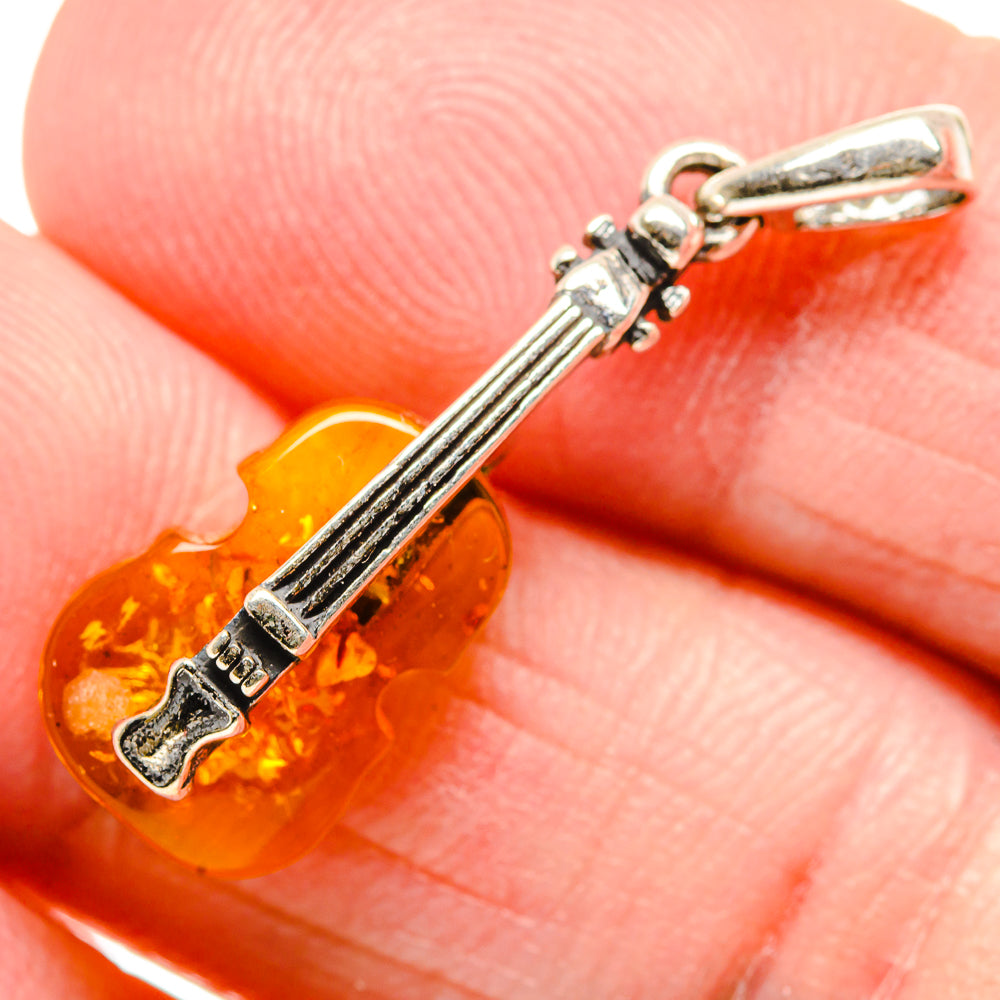 Amber guitar-shaped pendant with 925 sterling silver bail and key detail, close-up