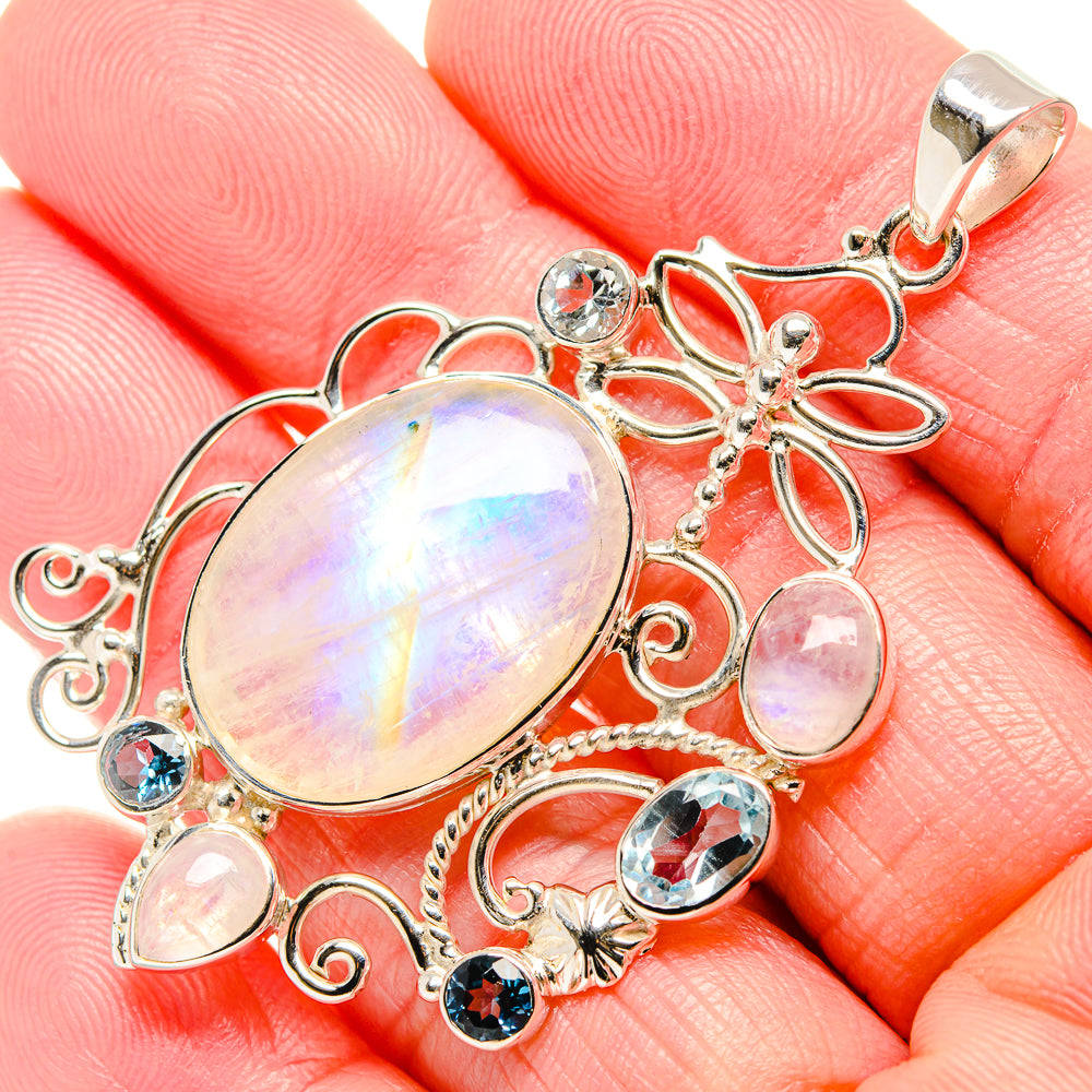 Rainbow moonstone oval pendant with blue topaz and floral sterling silver accents