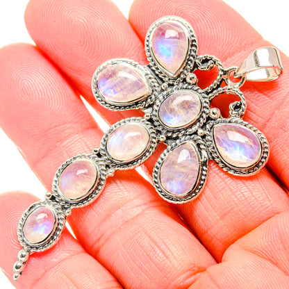 Sterling silver rainbow moonstone cross pendant with oval opal-like stones on hand