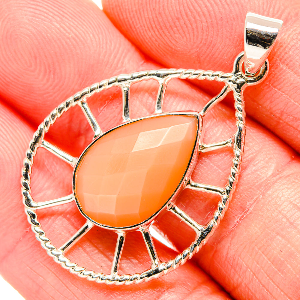 Close-up of peach moonstone teardrop pendant, sunburst frame and bail in 925 silver