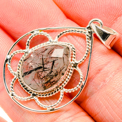 Oval rutilated quartz pendant close-up with braided silver loops and pointed bail