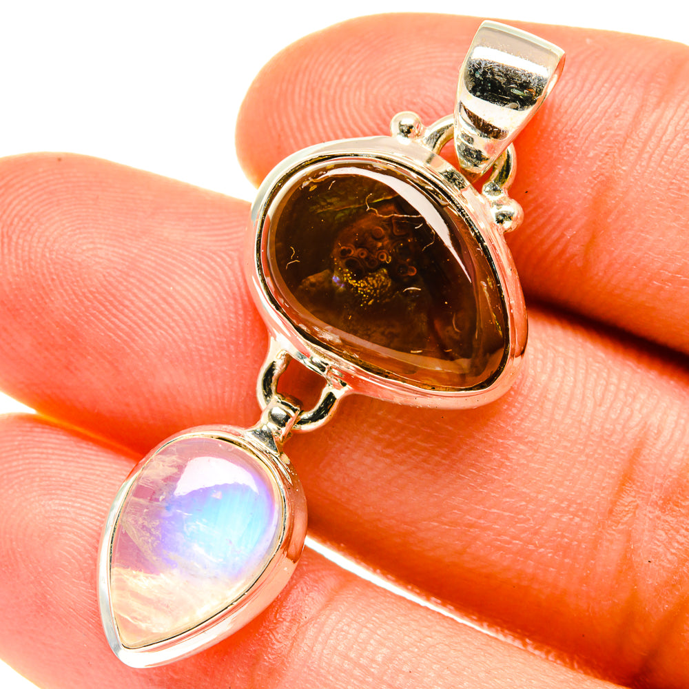 Sterling silver pendant close-up with glowing amber fire agate and iridescent moonstone