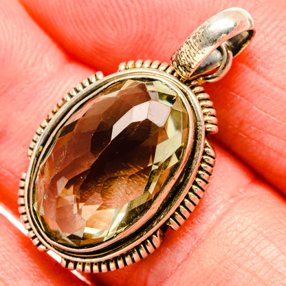 Oval faceted gemstone pendant with sterling silver setting and top loop, green-gold hue