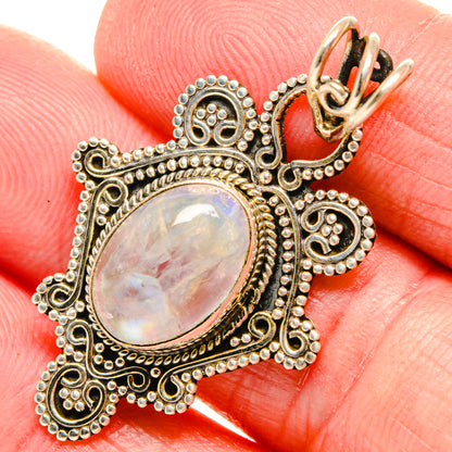 Close-up oval moonstone pendant with gold-tone prong setting and filigree border