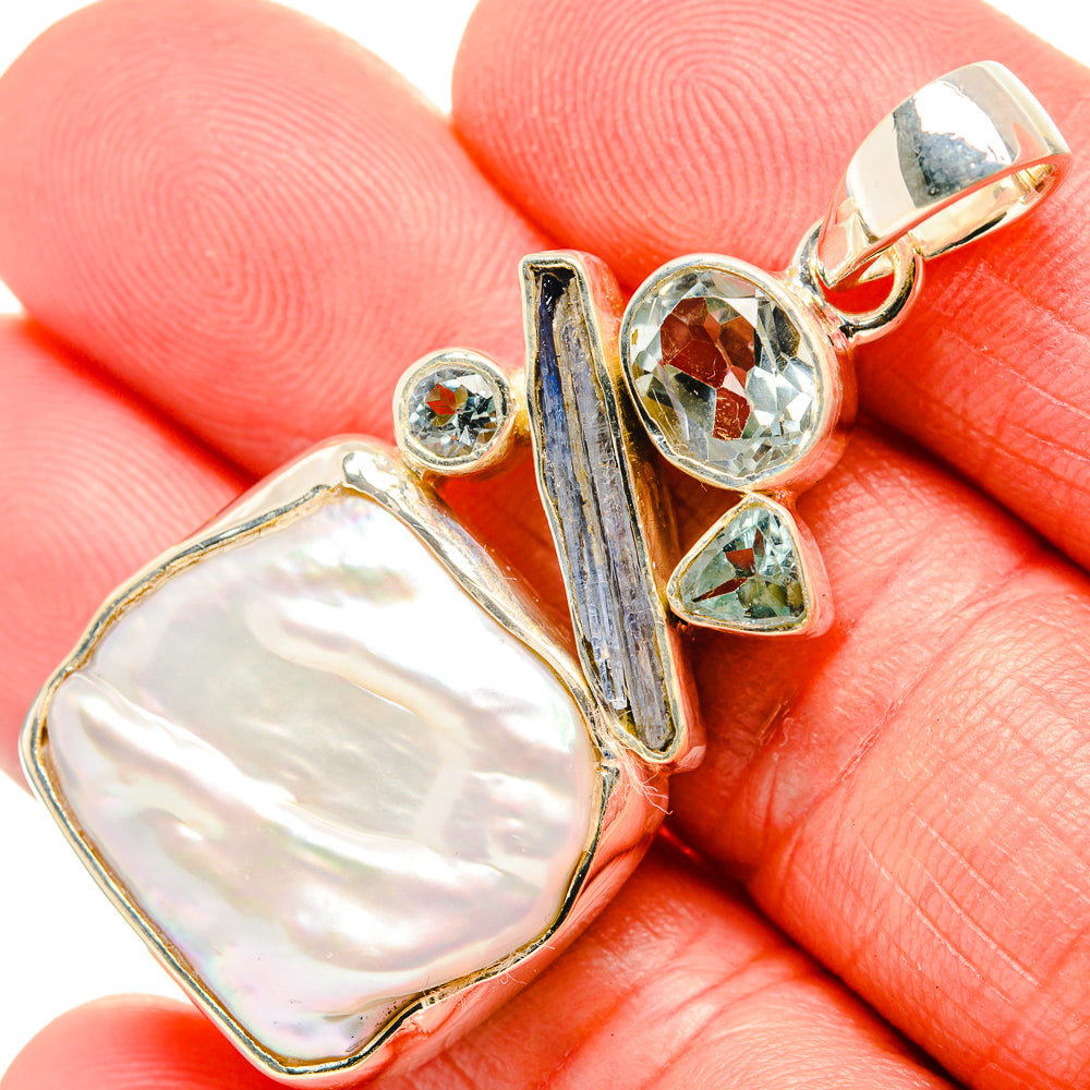 Sterling silver pendant with oval mother-of-pearl and blue gem accents