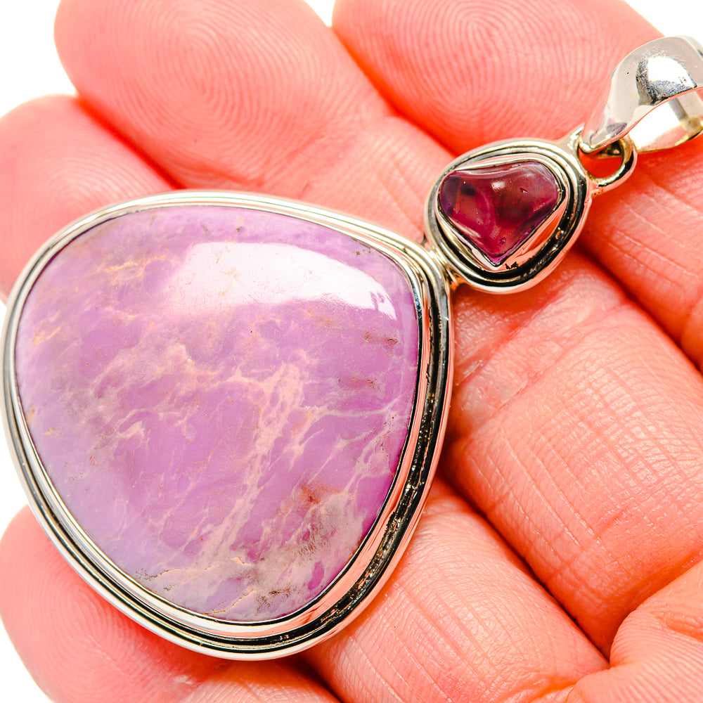 Close-up sterling silver pendant with oval purple stone and small red teardrop charm