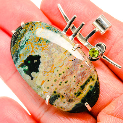 Ocean jasper cabochon pendant with round green peridot in sterling silver setting