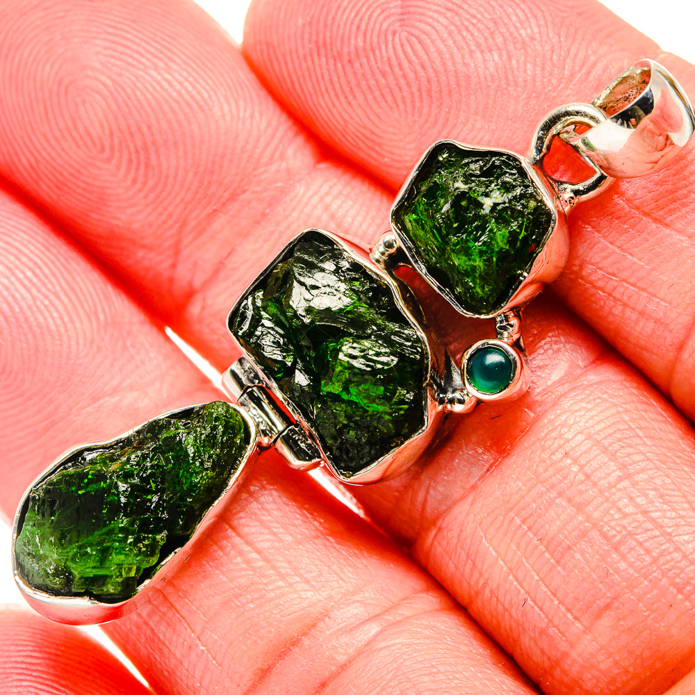 Sterling silver pendant close-up: three rough green diopside stones and round green gem