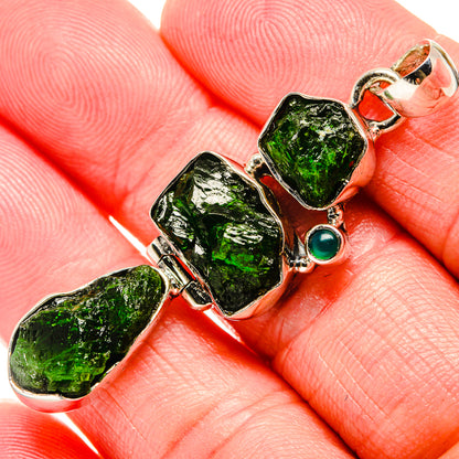 Sterling silver pendant close-up: three rough green diopside stones and round green gem