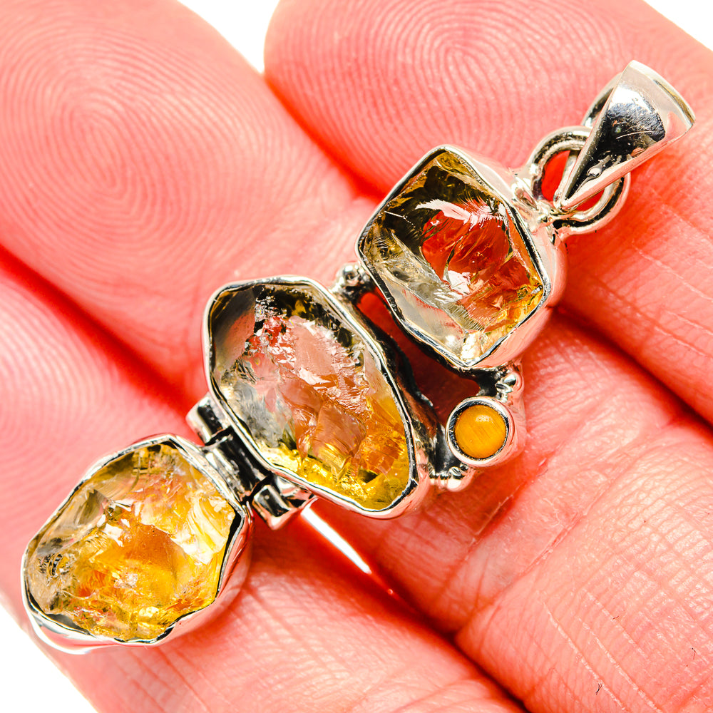 Sterling silver pendant with rough yellow stones, red-orange center stone, and top bail