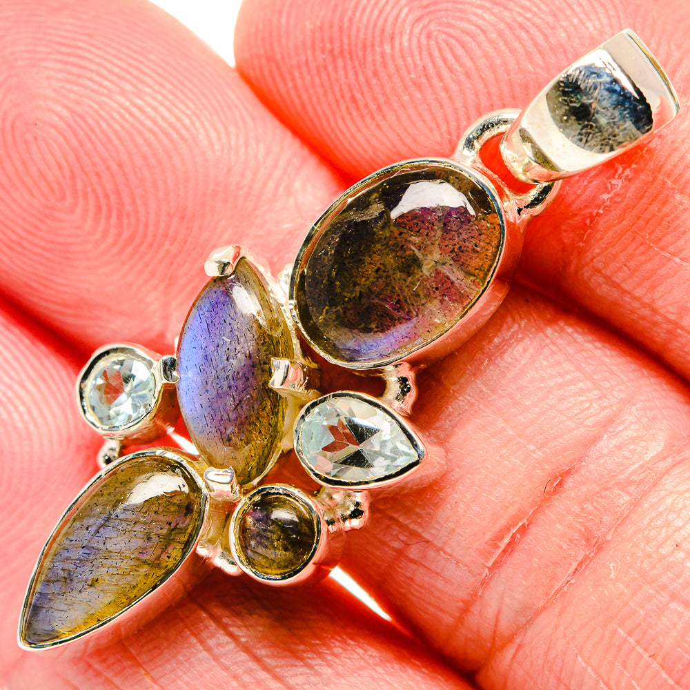 Sterling silver pendant close-up with labradorite oval center and blue topaz rounds