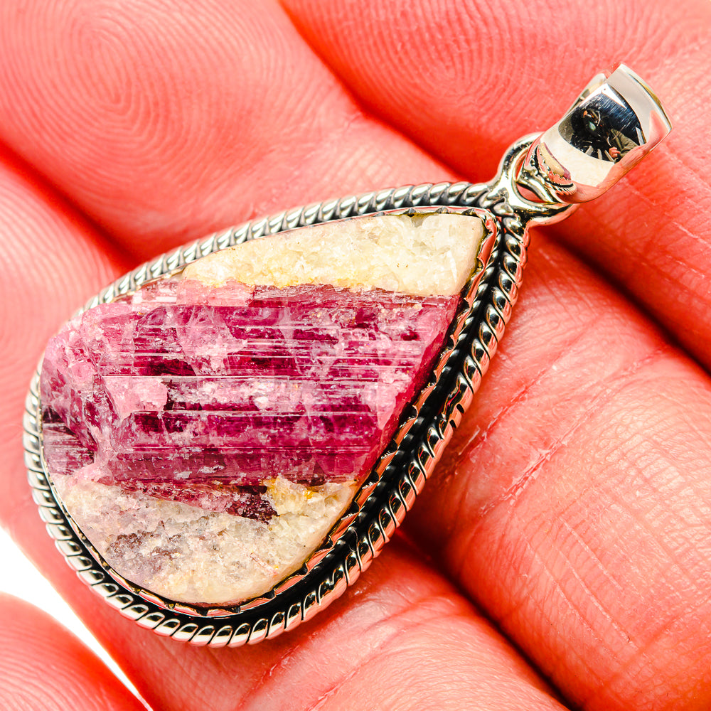 Close-up sterling silver teardrop pendant with pink cabochon stone and bail