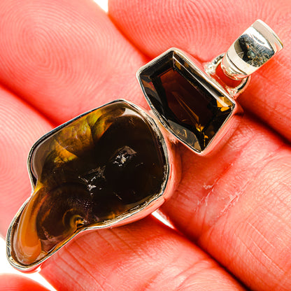 Sterling silver pendant with dark oval gemstone and rectangular smoky-toned stone, green bail