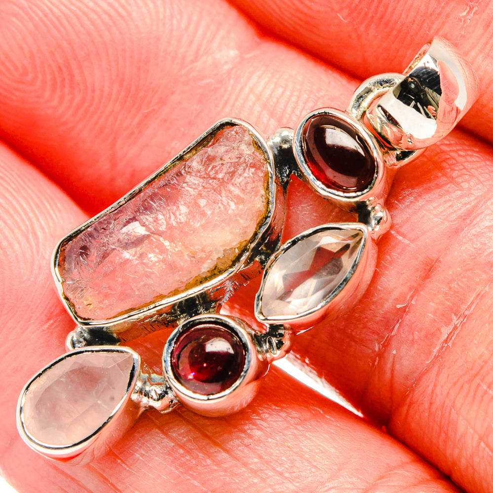 Close-up sterling silver pendant with rough rose quartz, red garnet and clear stone