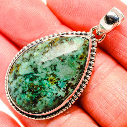 Tibetan turquoise teardrop pendant in silver setting, detailed border and clasp loop