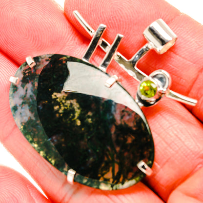 Green moss agate pendant close-up with round peridot bezel and silver bar bail