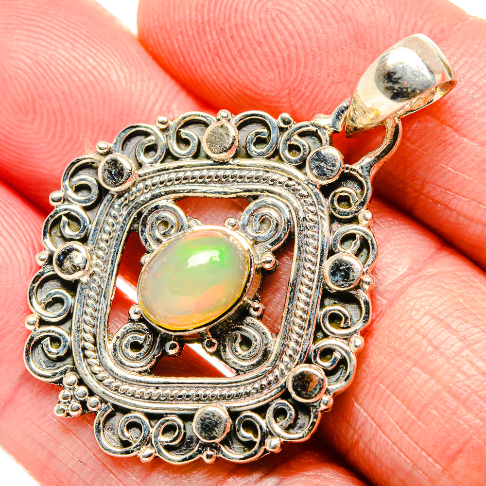 Sterling silver opal pendant with oval green-yellow cabochon and ornate filigree setting