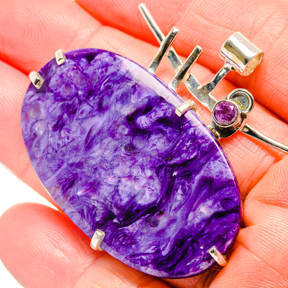 Large oval purple gemstone pendant with silver setting and round purple accent