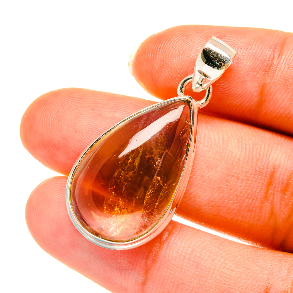 Citrine teardrop pendant in 925 sterling silver on hand, amber translucent stone