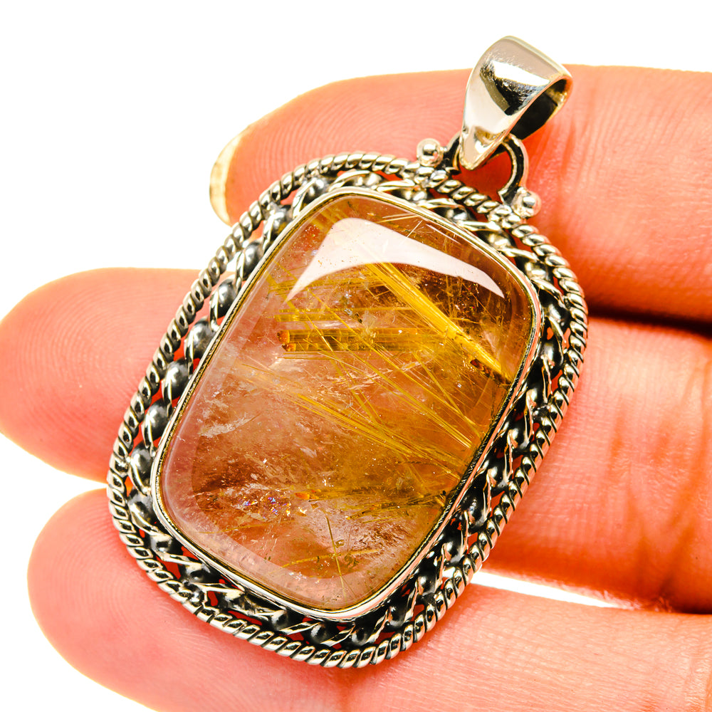 Rutilated quartz pendant with oval amber-gold stone and ornate sterling silver frame
