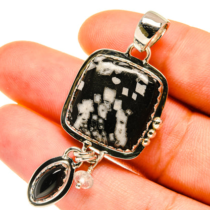 Sterling silver pendant close-up: black-and-white square stone with oval black charm