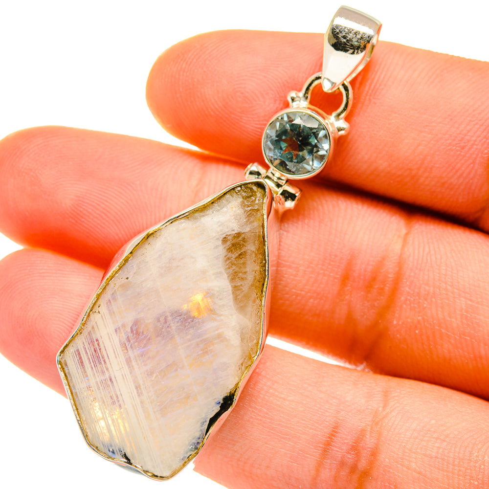 Sterling silver pendant close-up with round blue gemstone and pear-shaped opal-like stone