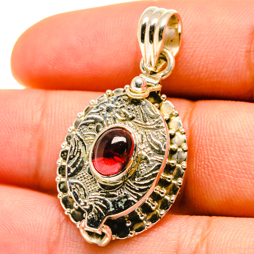 Sterling silver garnet pendant with oval red gemstone and ornate halo frame