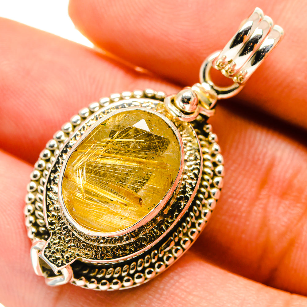 Rutilated quartz pendant close-up with yellow-gold oval stone and silver bead border.