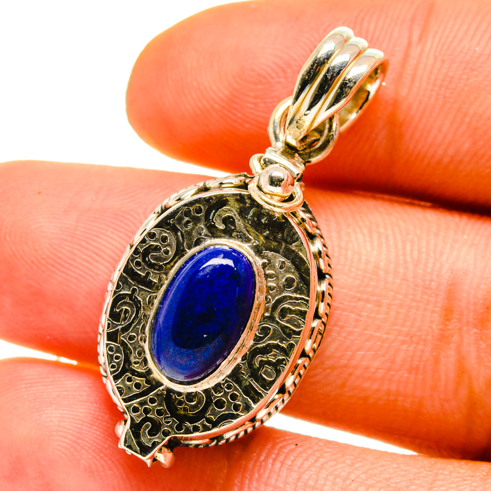 Lapis lazuli pendant with oval blue stone, ornate gold-tone frame and loop bail