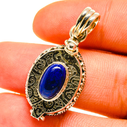 Lapis lazuli pendant with oval blue stone, ornate gold-tone frame and loop bail