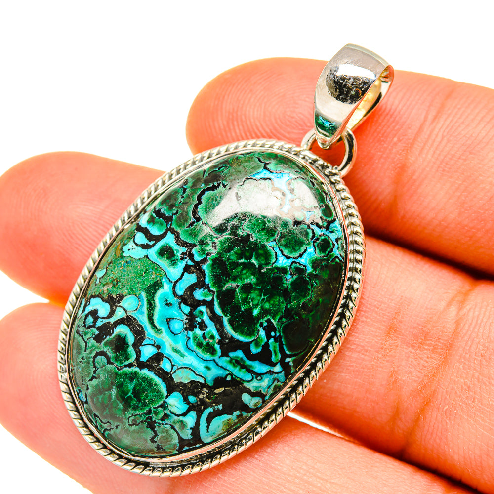 Close-up oval green-blue stone pendant with textured silver rim and bail