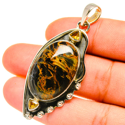 Oval pietersite pendant in polished silver with yellow citrine side stones and bail