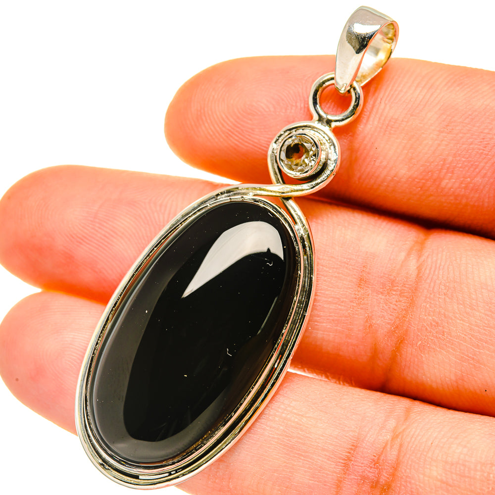 Oval black onyx pendant with quartz accent, 925 sterling silver setting and loop bail