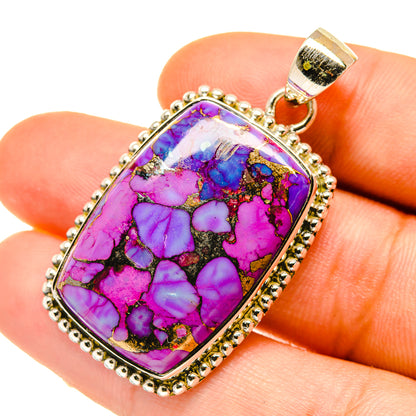Purple-blue turquoise pendant in gold-tone oval frame with loop bail, close-up.