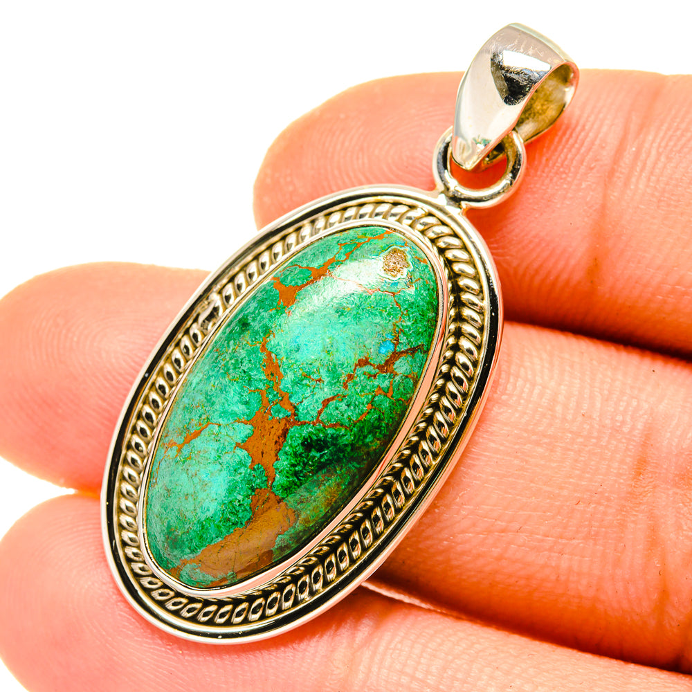 Oval chrysocolla pendant with green stone cabochon, detailed frame, and loop bail