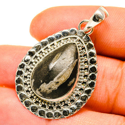 Oval stone pendant in sterling silver bezel with dark pinolith and bead border