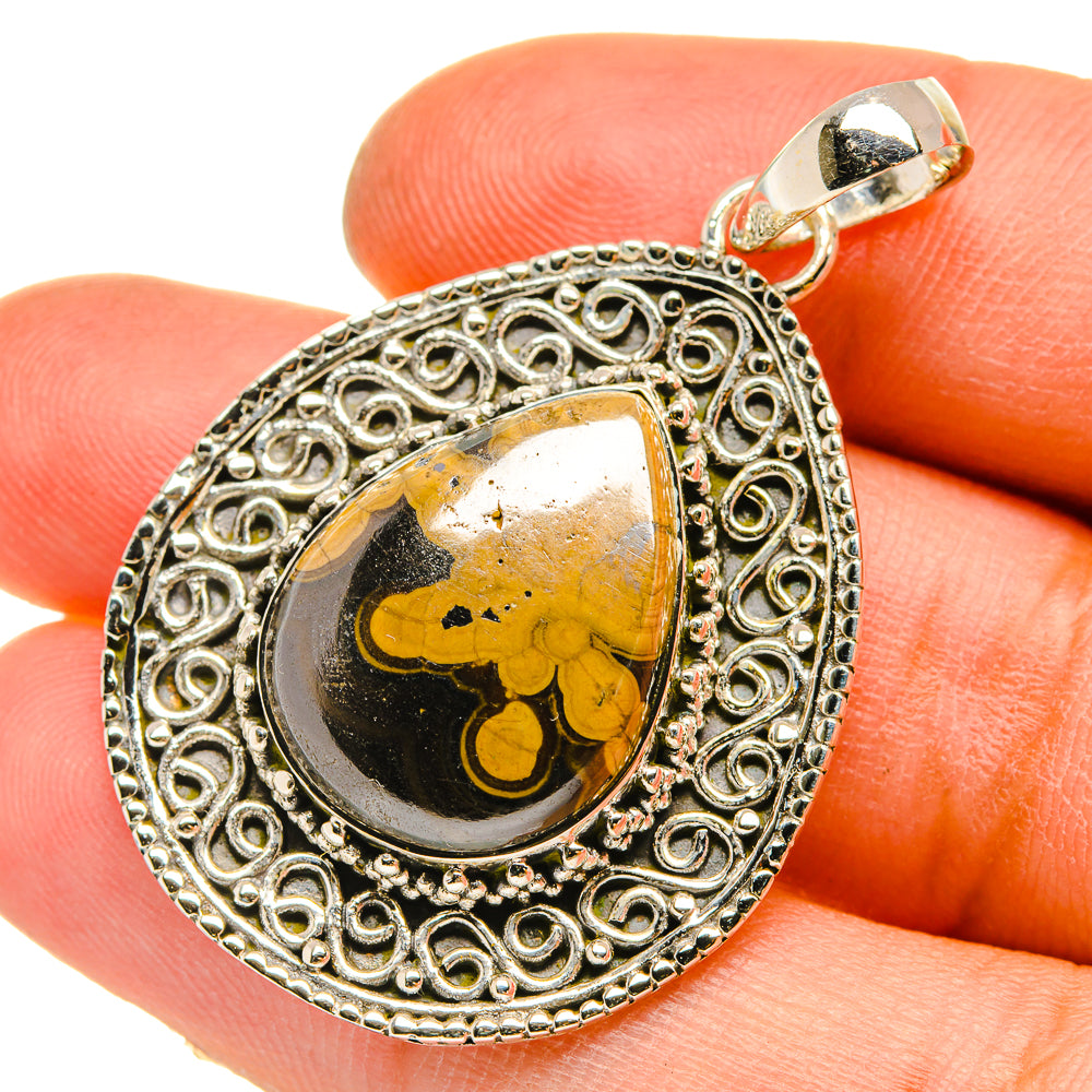 Sterling silver teardrop pendant with ornate filigree and black-and-yellow cabochon