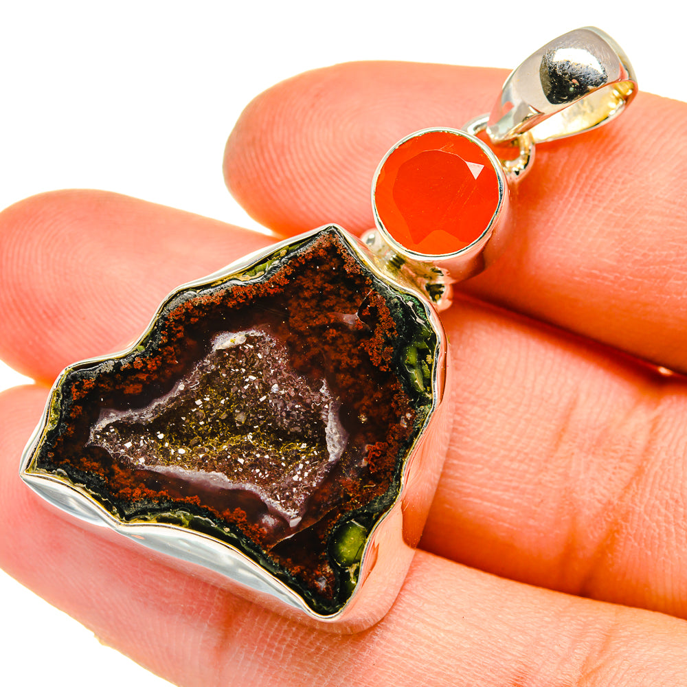 Carnelian round stone and dark druzy geode pendant, gold-tone bail, on hand