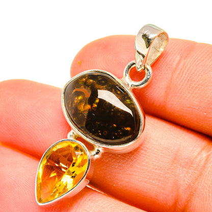Fire agate and citrine pendant close-up with oval dark stone and yellow teardrop in silver