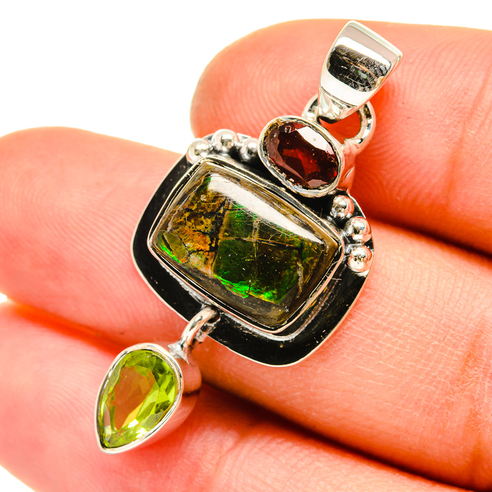 Sterling silver pendant with iridescent ammolite center, garnet oval, and green peridot drops