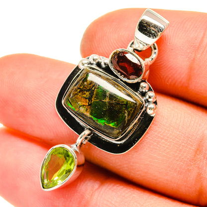 Sterling silver pendant with iridescent ammolite center, garnet oval, and green peridot drops