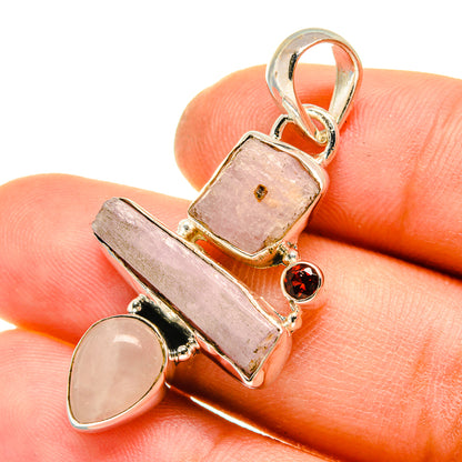 Sterling silver pendant with rough pink kunzite, pale round stone, and small red garnet