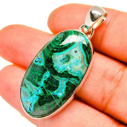 Oval malachite-chrysocolla pendant in hand, green-blue stone in silver bezel